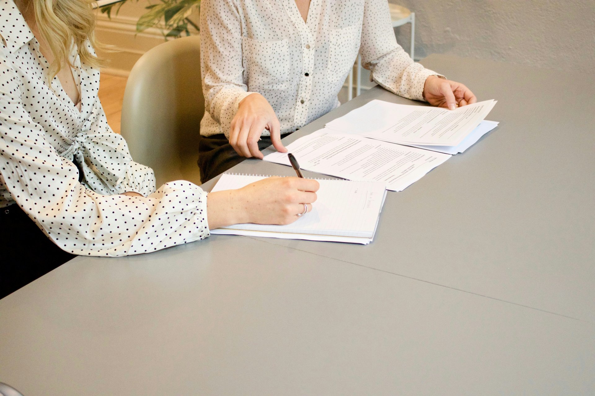 Hands reviewing documents at table